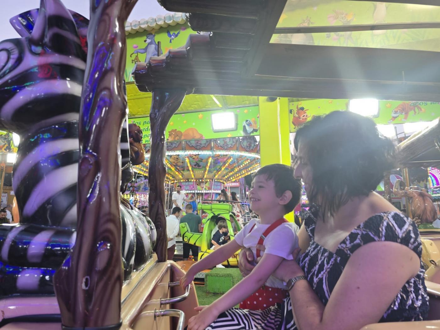 Un niño, con su madre ayer en la feria de Algeciras - A.I.