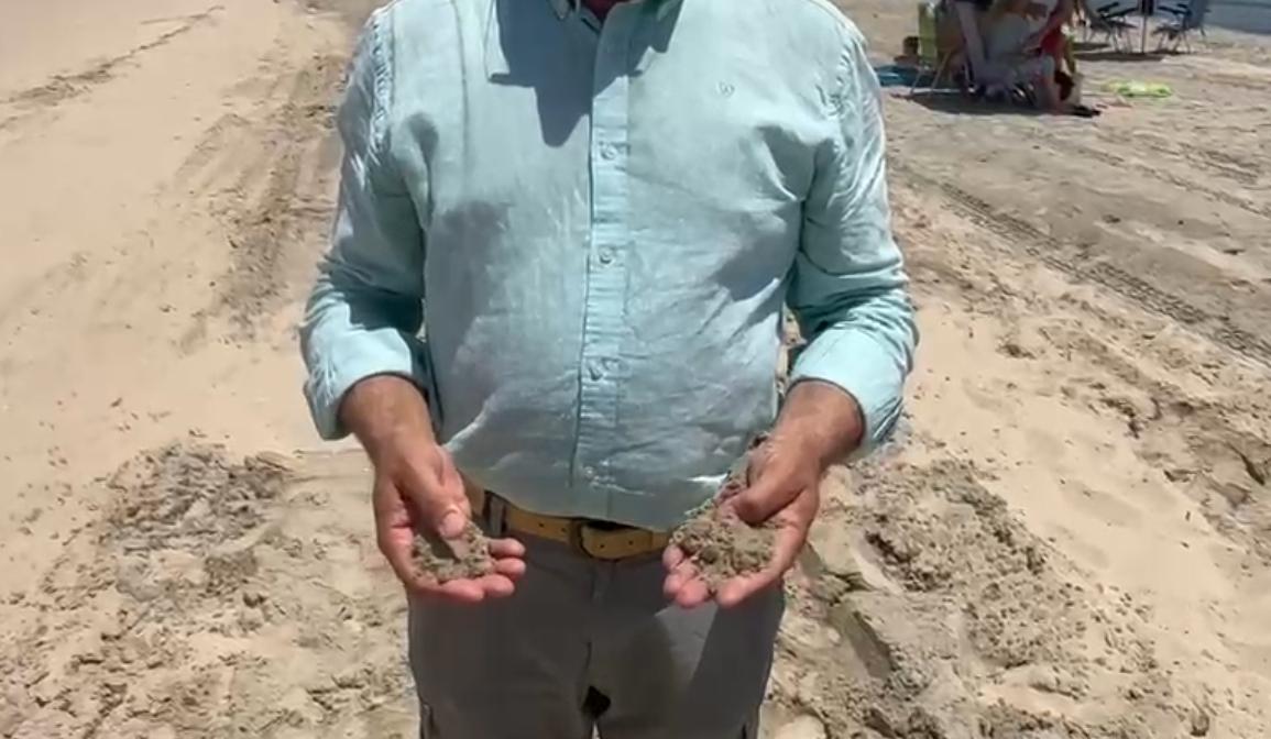 Martínez muestra la arena trasvasada en El Rinconcillo. - AI