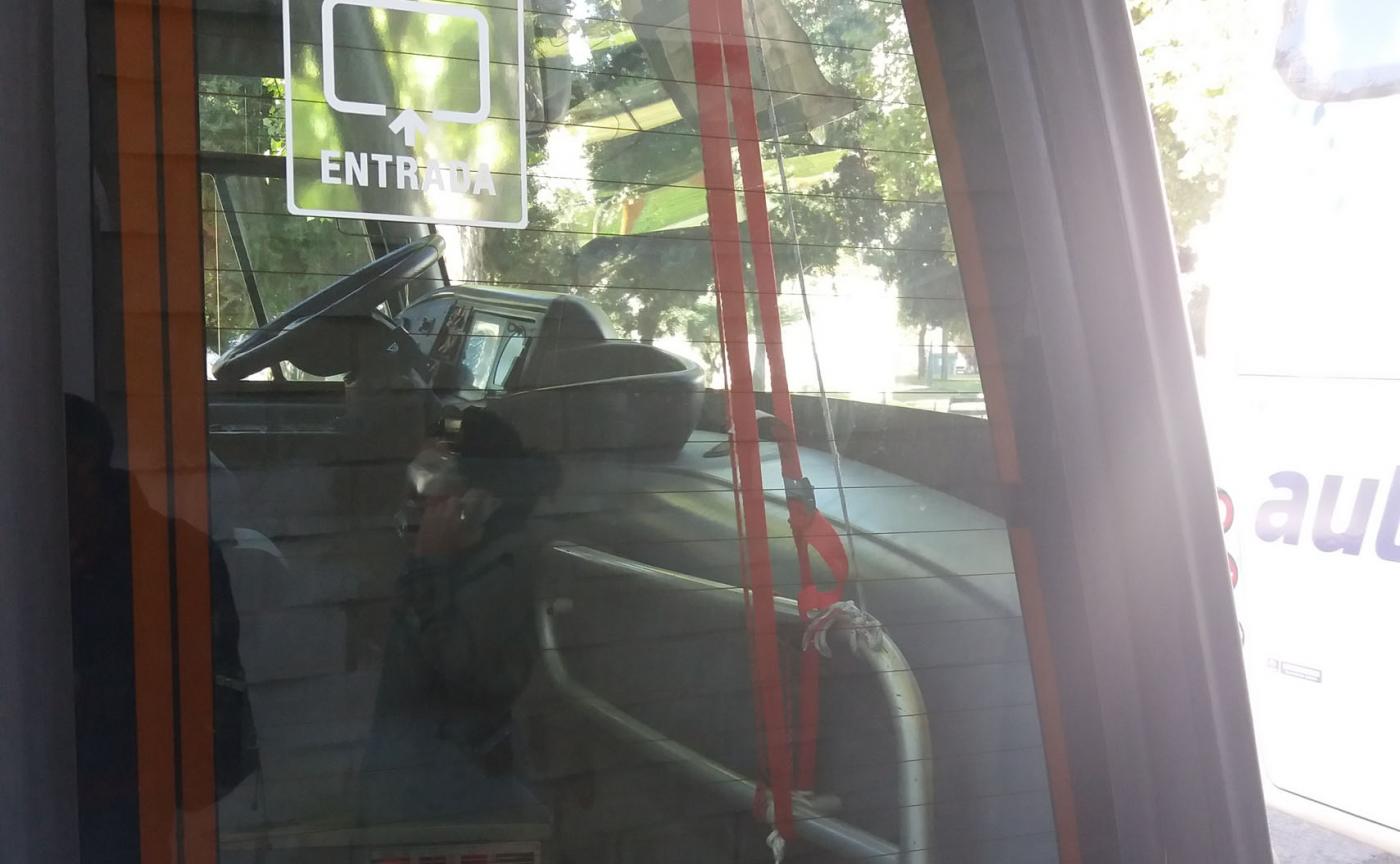 Uno de los autobuses con la puerta delantera atada con cuerdas 